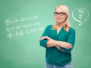 Image showing happy woman in eyeglasses over school blackboard