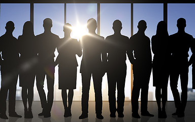 Image showing business people silhouettes over office background