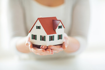 Image showing close up of hands holding house or home model