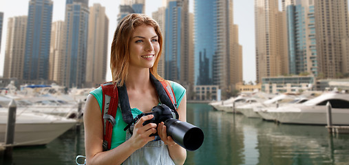 Image showing woman with backpack and camera over dubai city