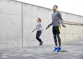 Image showing man and woman exercising with jump-rope outdoors