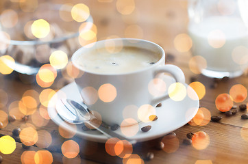 Image showing close up coffee cup and grains on wooden table