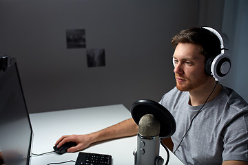 Image showing man in headset playing computer video game at home