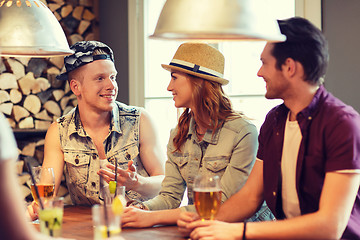 Image showing happy friends drinking beer and cocktails at bar