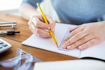 Image showing close up of hands with ruler and pencil drawing 