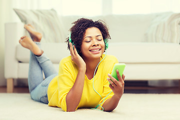 Image showing happy african woman with smartphone and headphones