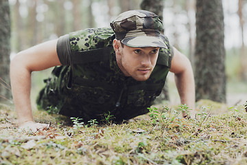 Image showing young soldier or ranger doing push-ups in forest