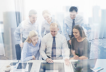 Image showing smiling business people with laptop in office