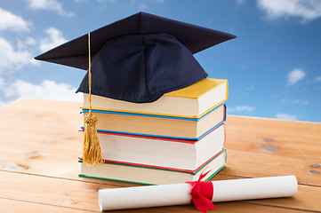 Image showing close up of books with diploma and mortarboard