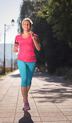 Image showing sporty woman running  on sidewalk