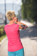 Image showing jogging woman setting phone before jogging