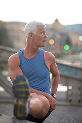 Image showing handsome man stretching before jogging