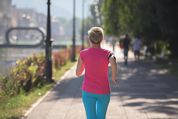 Image showing sporty woman running  on sidewalk