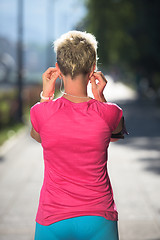 Image showing jogging woman setting phone before jogging