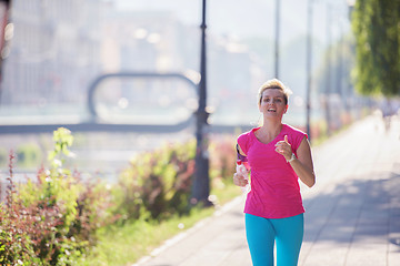 Image showing sporty woman running  on sidewalk