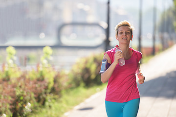 Image showing sporty woman running  on sidewalk