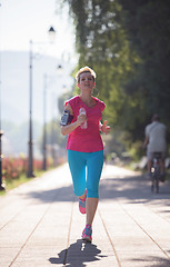 Image showing sporty woman running  on sidewalk