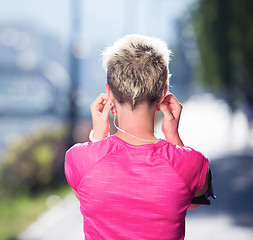 Image showing jogging woman setting phone before jogging