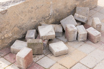 Image showing Pieces of old paving slabs lie in a concrete block on the pavement