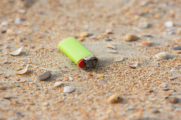 Image showing Old used lighter in the sand on the beach