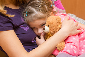 Image showing Little girl with a teddy bear clung to her mother with a sad expression on his face