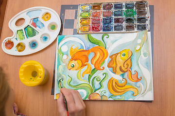 Image showing Top view of the process of drawing on watercolor paper goldfish