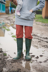 Image showing woman in rubber boots standing in a puddle