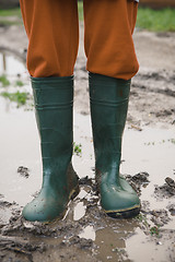 Image showing woman in rubber boots standing in a puddle