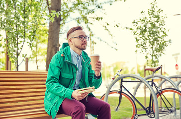 Image showing happy young hipster man with coffee and sandwich