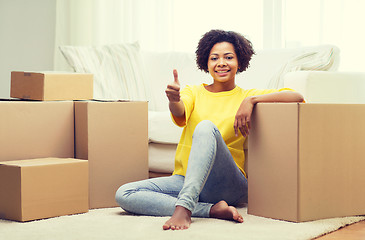 Image showing happy african woman with cardboard boxes at home