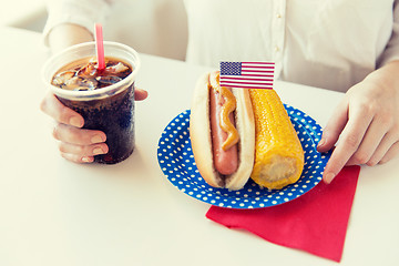 Image showing close up of woman eating hot dog with cola