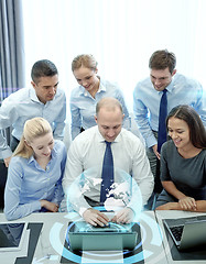 Image showing smiling business people with laptop in office