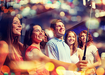 Image showing friends with smartphone taking selfie in nightclub