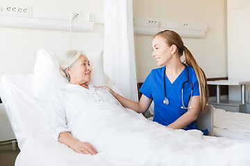 Image showing doctor or nurse visiting senior woman at hospital