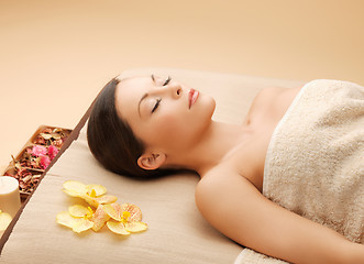 Image showing woman in spa salon lying on the massage desk