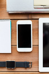 Image showing close up of smartphone and smartwatch on table