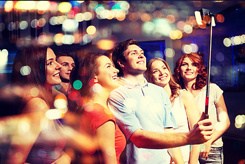 Image showing friends with smartphone taking selfie in club