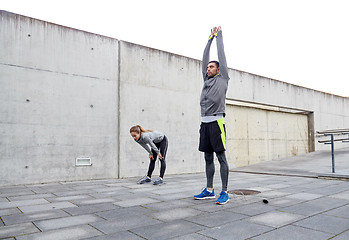 Image showing tired couple stretching after exercise
