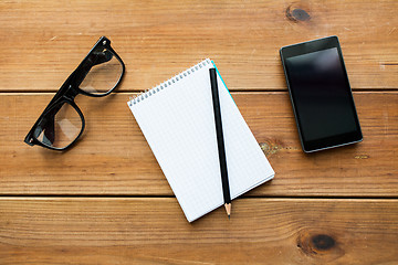 Image showing close up of notepad, smartphone and eyeglasses