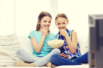 Image showing happy girls with popcorn watching tv at home
