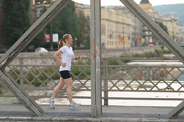 Image showing sporty woman running  on sidewalk