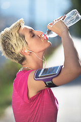 Image showing woman drinking  water after  jogging
