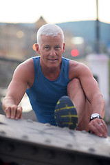 Image showing handsome man stretching before jogging