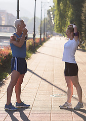 Image showing couple warming up and stretching before jogging