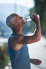 Image showing senior jogging man drinking fresh water from bottle