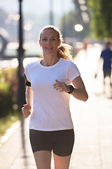 Image showing sporty woman running  on sidewalk