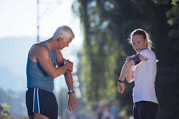 Image showing jogging couple planning running route  and setting music