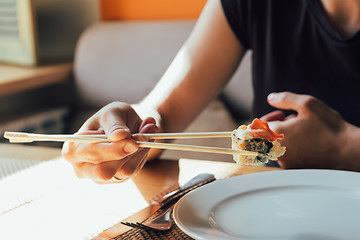 Image showing girl eating sushi in restaurant