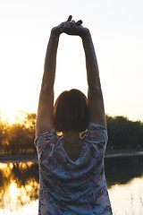 Image showing the girl raised her arms up at sunset