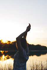 Image showing the girl raised her arms up at sunset